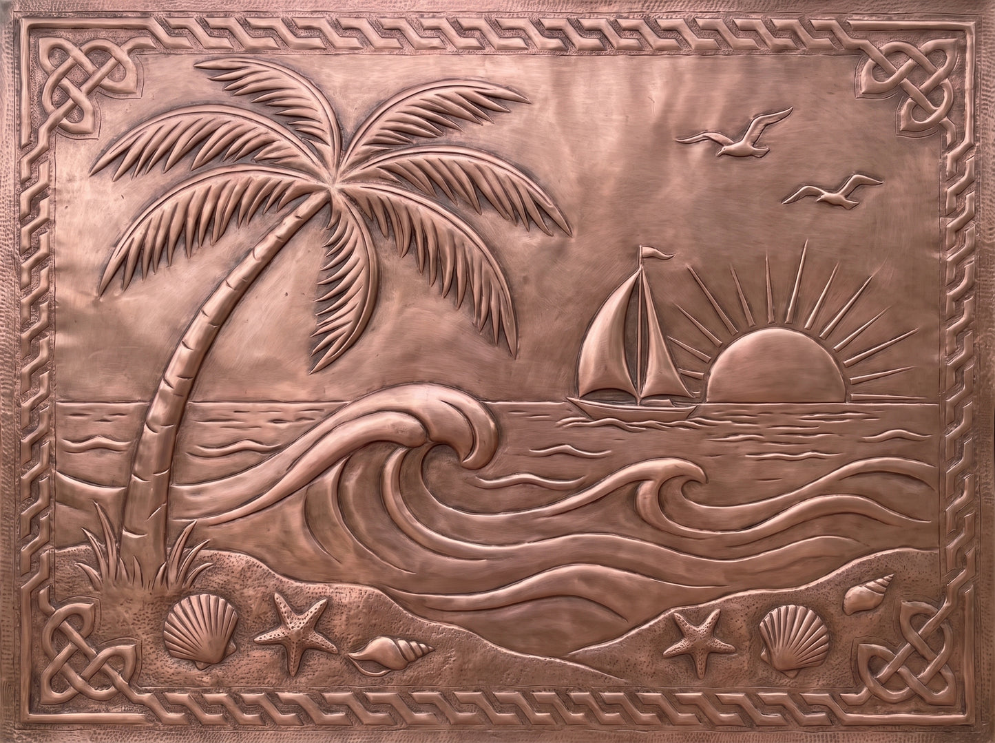 Handcrafted copper kitchen backsplash with palm tree, ocean waves, sailboat, sunset, and seashells