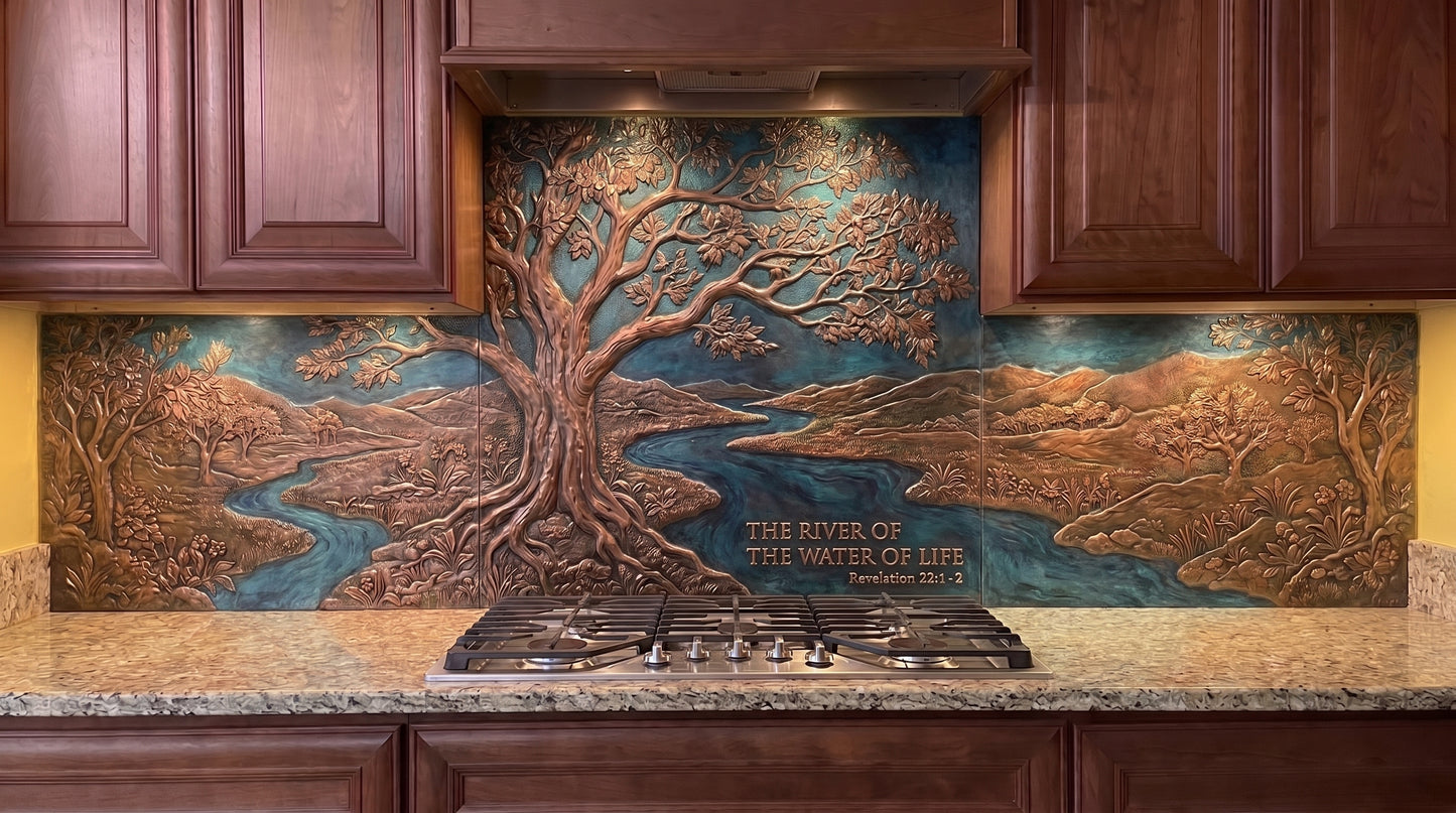 Tree of Life at the River Bend copper kitchen backsplash inspired by Revelation 22:1–2, featuring a large spreading Tree of Life beside a curving river with foliage, distant landscape, and natural scenery formed in raised metal relief across the range wall.