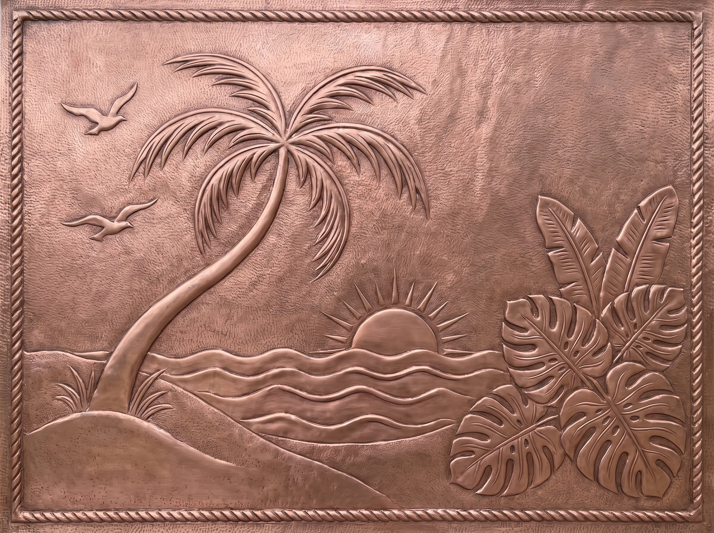 Handcrafted copper kitchen backsplash with tropical palm tree, ocean sunset, and lush tropical leaves