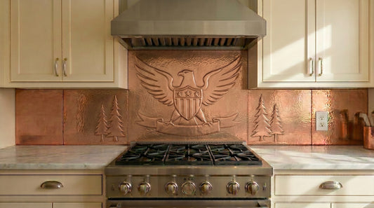 Handcrafted copper backsplash behind range featuring an American eagle relief design. Made from real copper for stove and cooktop areas. Custom sizes and finishes available for complete copper kitchen backsplash installations.