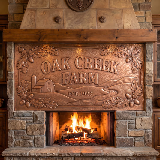 Personalized family farm sign hand-hammered from real copper, featuring Oak Creek Farm and Est. 1923 in raised lettering with a barn, winding creek, rolling farmland, oak leaves, and acorns in raised copper relief, displayed above a stone fireplace.