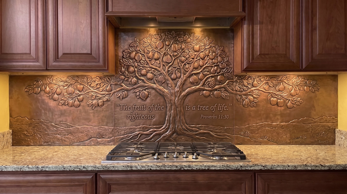 Handcrafted Fruitful Tree of Life copper kitchen backsplash inspired by Proverbs 11:30, featuring a broad fruit-bearing tree in raised relief behind the range with branches, visible fruit, roots, and natural landscape elements extending across the copper backsplash under the cabinets.