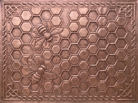 Handcrafted copper kitchen backsplash with raised honeybees and honeycomb pattern