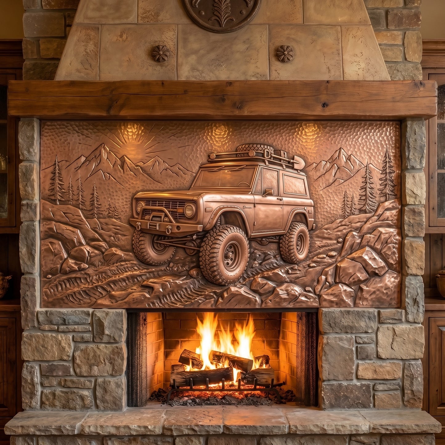 A rustic stone fireplace with a large copper relief panel depicting a rugged off-road vehicle traveling through mountains and trees, with a warm fire burning below.