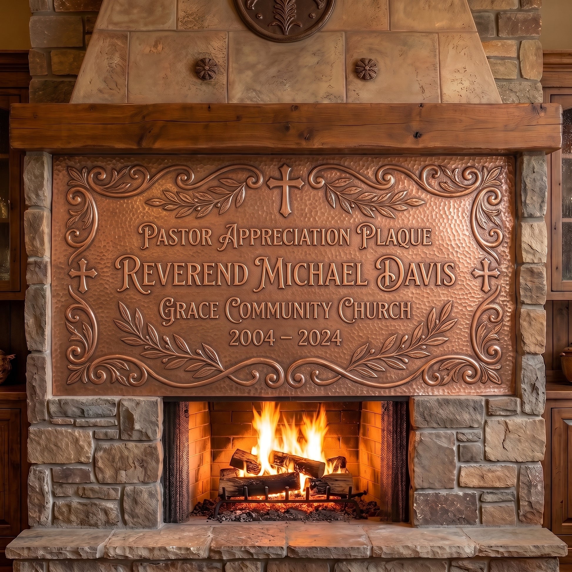 Hand-hammered personalized pastor appreciation plaque made from real copper, displayed above a stone fireplace and featuring Reverend Michael Davis, Grace Community Church, 2004–2024, raised copper lettering, Christian crosses, leafy branches, and decorative scrollwork on a textured copper background.