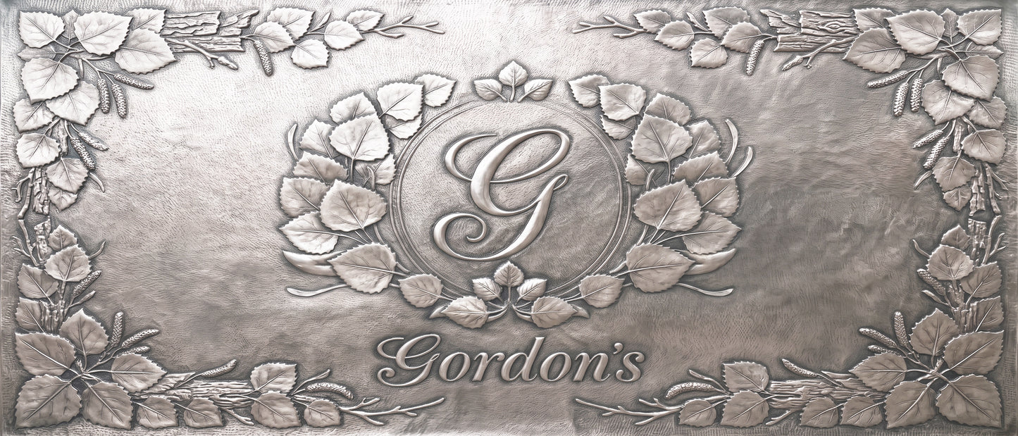 Personalized Quaking Aspen copper kitchen backsplash with custom family initial and name surrounded by raised aspen leaves and branches