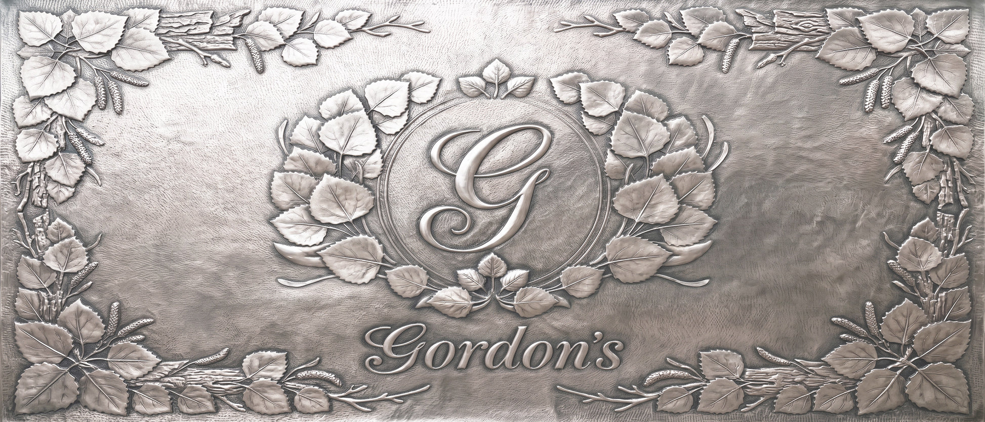 Personalized Quaking Aspen copper kitchen backsplash with custom family initial and name surrounded by raised aspen leaves and branches