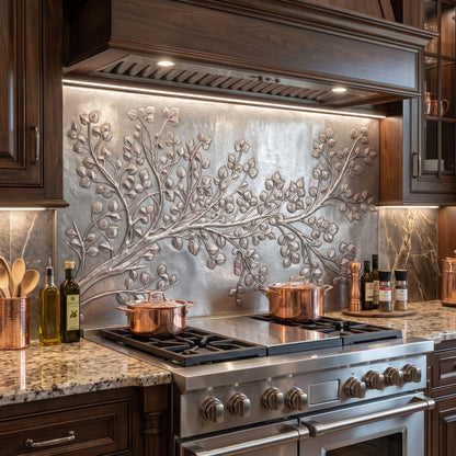 Aspen Branch metal kitchen backsplash with raised quaking aspen leaves and hand-hammered background installed behind a stainless steel range