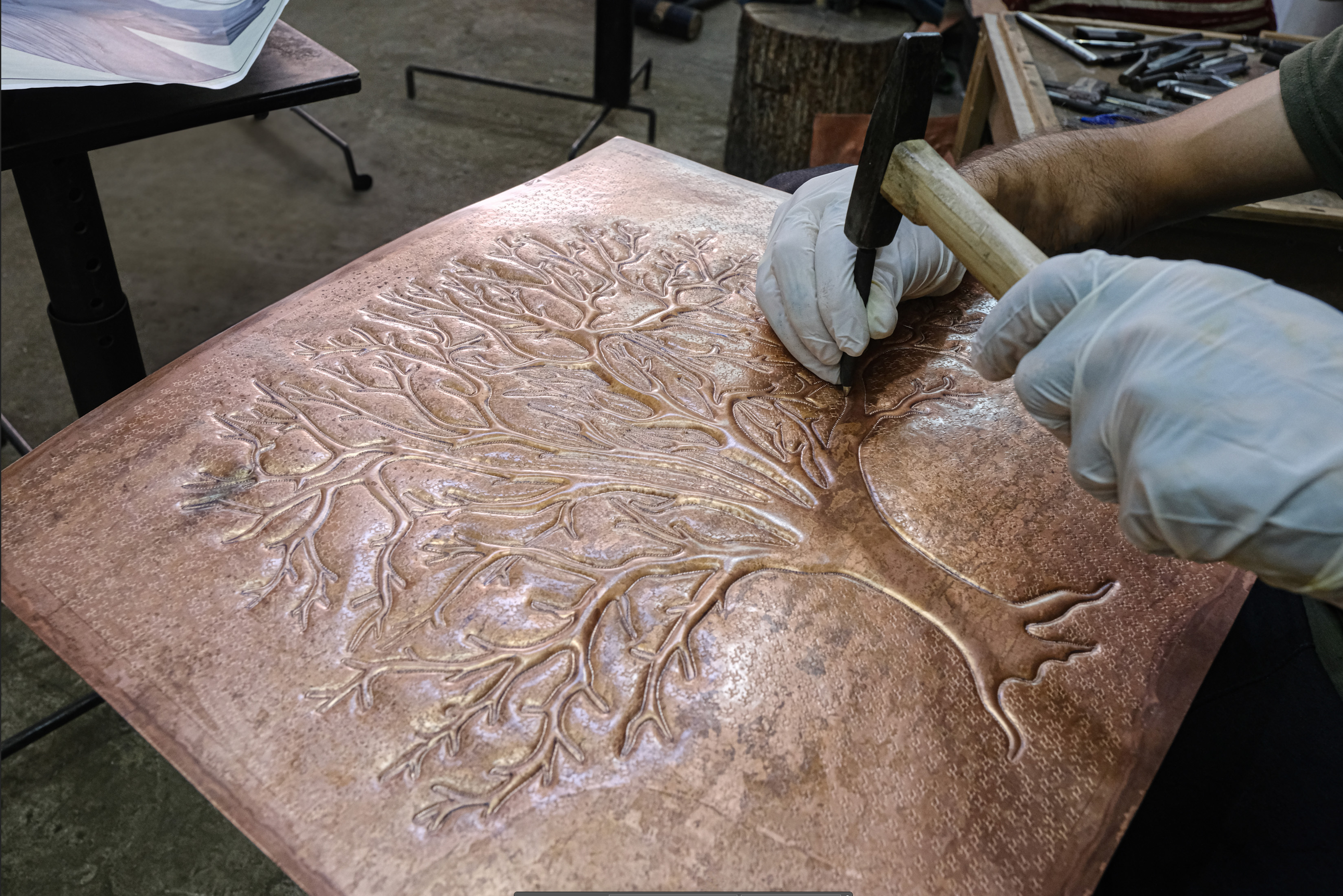 Hand-hammering a copper kitchen backsplash tree of life