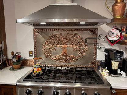 Handcrafted copper kitchen backsplash featuring an intricate sacred tree with Celtic-inspired knotwork roots and branches. Custom sizes available for stove backsplashes, range walls, and full kitchen backsplash installations.