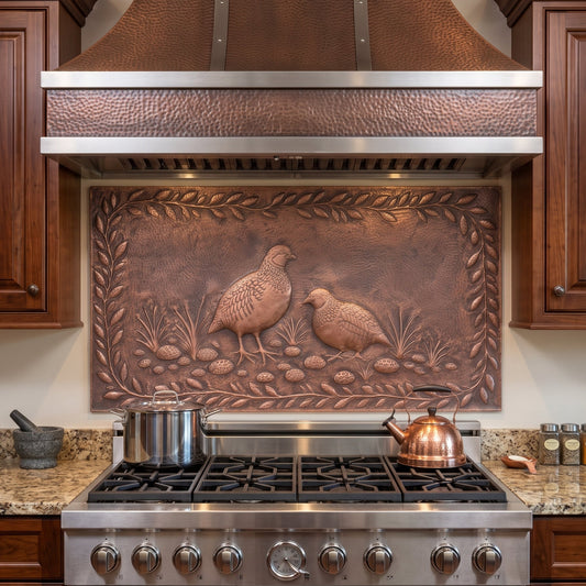A copper kitchen backsplash tile featuring embossed birds and foliage, installed behind a stainless steel gas range in a wood cabinetry kitchen.