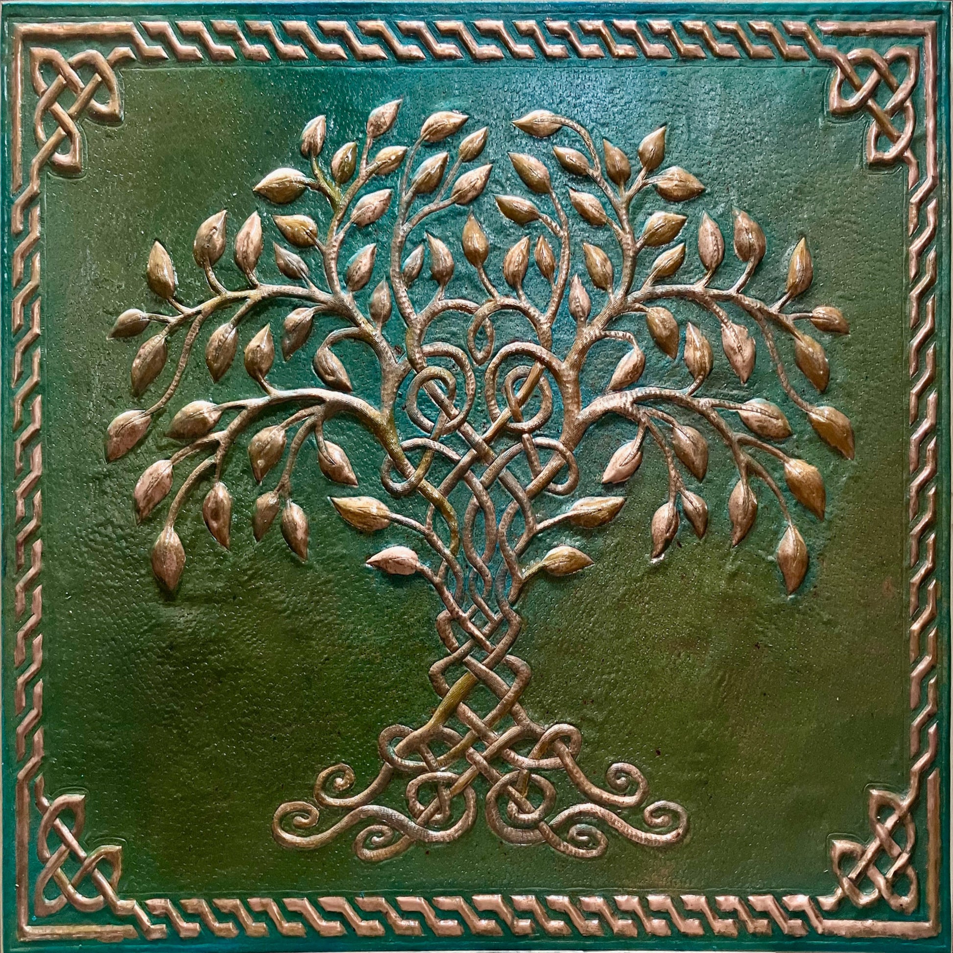 A square decorative wall tile featuring a raised Celtic-style tree of life motif in metallic bronze tones over a textured dark green background, surrounded by a matching ornate border.