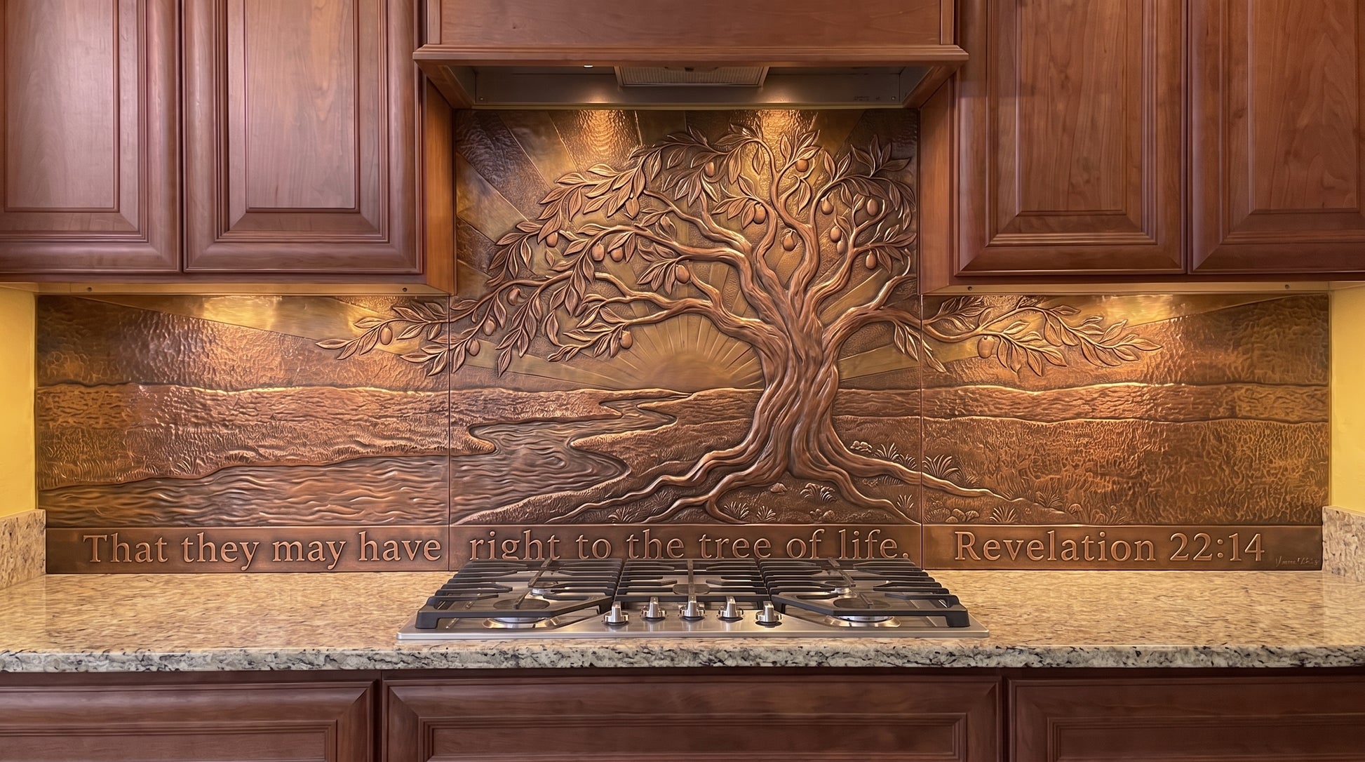 Tree of Life at Dawn copper kitchen backsplash inspired by Revelation 22:14, featuring a large Tree of Life beside living water with an open landscape and the impression of dawn formed through raised metalwork and textured copper across the range-wall backsplash.