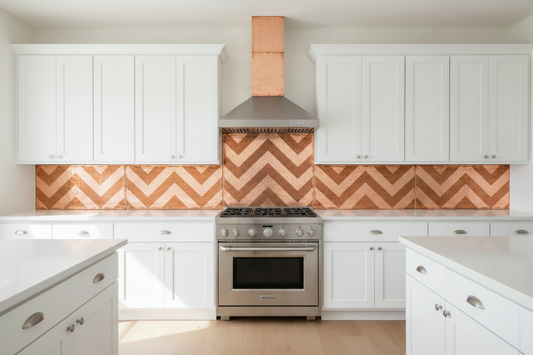 Three separate hand-hammered copper backsplash panels with bold herringbone chevron repoussé design installed symmetrically behind centered professional range — tall center panel with equal side panels left and right