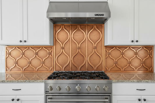 Hand-hammered copper kitchen backsplash with ogee lattice relief pattern, shown as a 3-piece installation with tall center panel behind stove and shorter side panels, natural copper finish